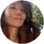 Frau Son sieht zur Seite. Im Hintergrund befindet sich ein grüner Baum.